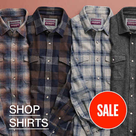 Flatlay of 4 men's plaid shirts lined up in a row. 